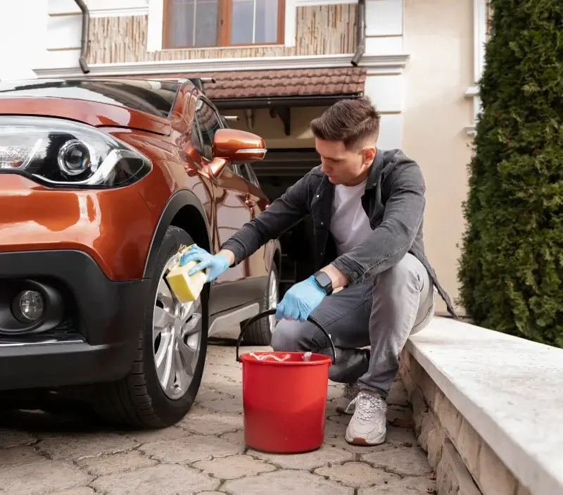 Lavage auto à domicile Sillé-le-Guillaume : professionnel intervenant sur un véhicule